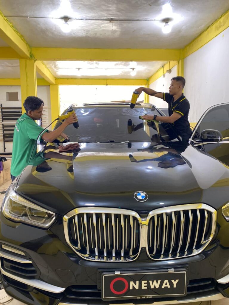 Teknisi profesional sedang memasang kaca film One Premium di Medan